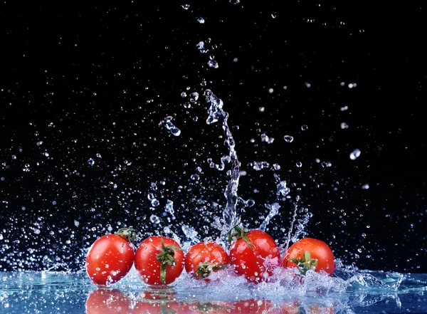 Studio shot with freeze motion of cherry tomatoes in water splas Stock Photo