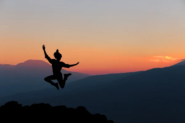 快乐的女人在美丽的日落前跳跃.自由、享受的概念. — 图库照片