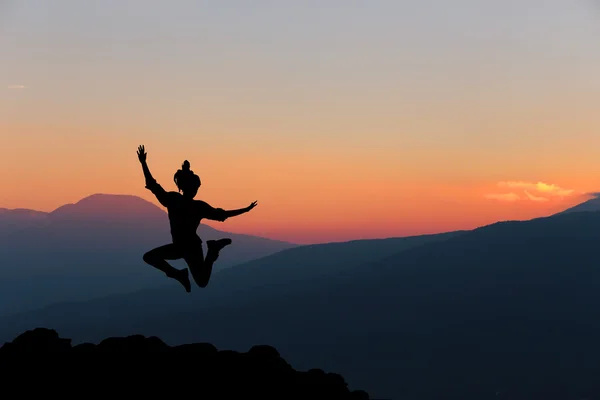 Donna felice che salta contro un bel tramonto. Libertà, godimento . — Foto Stock