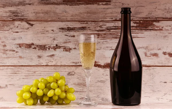 Kieliszek wina, butelkę wina i winogron na pokładzie — Zdjęcie stockowe