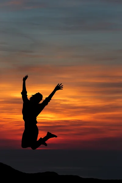 Mulher feliz saltando contra o belo pôr do sol. Liberdade, gozo — Fotografia de Stock