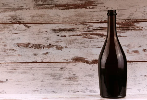 Botella de vino tinto sobre un fondo de madera — Foto de Stock