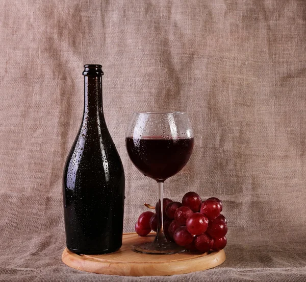 Vin rouge, fromages et raisins dans une configuration nature morte . — Photo