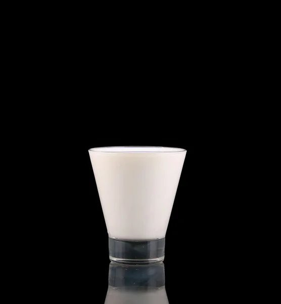 Spruzzare in un bicchiere con il latte isolato su nero — Foto Stock