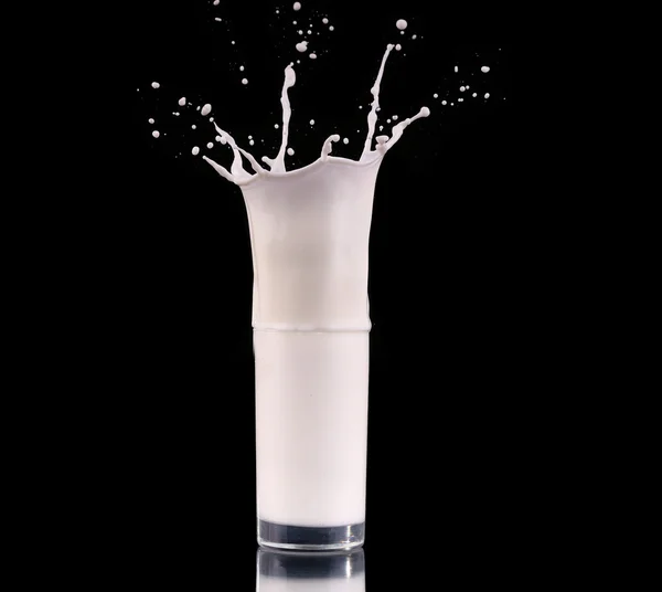 Salpicadura en un vaso con leche aislada en negro —  Fotos de Stock
