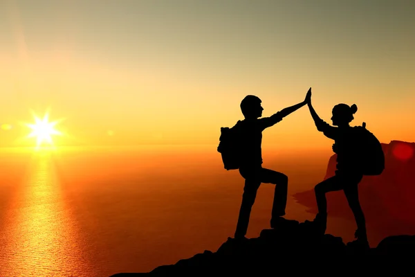 La silhouette di due uomini con gesto di successo in piedi sulla cima della montagna — Foto Stock