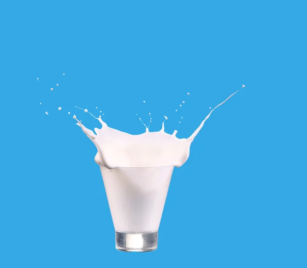牛奶浇玻璃隔绝了反对蓝色背景 — 图库照片