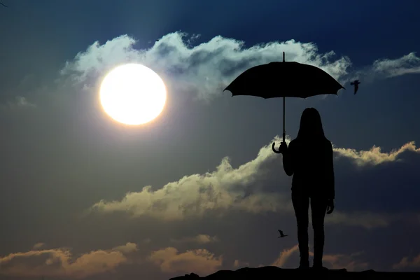Deštník žena stojan a sunset silueta — Stock fotografie