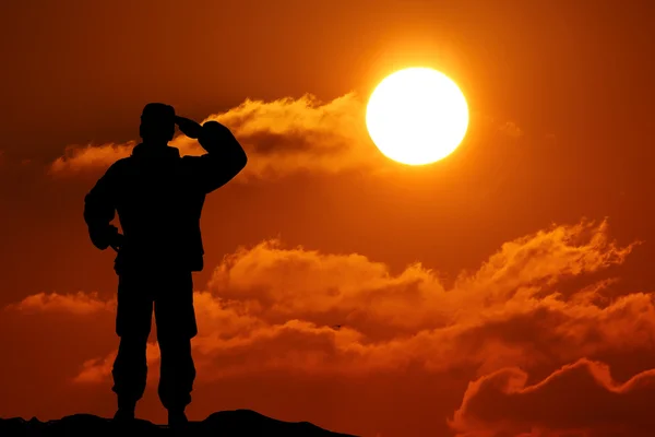 Silhueta de soldado com rifle contra um pôr-do-sol — Fotografia de Stock