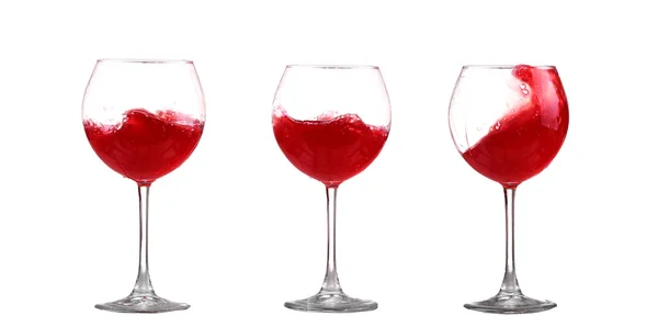 Червоне вино бризкає в склянці, ізольоване на білому — стокове фото