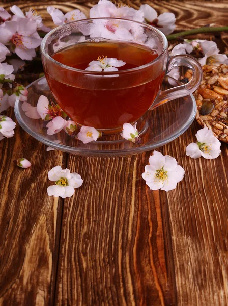 Té y una rama de flores de cerezo en una madera — Foto de Stock