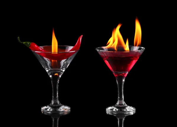 黒の背景に火とマティーニのグラスで唐辛子 — ストック写真