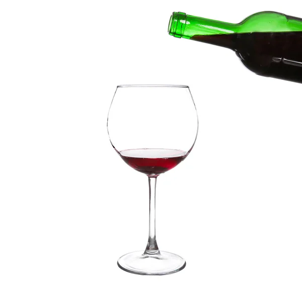 Red wine pouring from bottle into big glass on white background — Stock Photo, Image