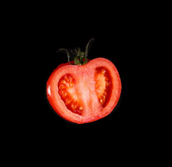 Die rote Tomate halb geschnitten auf schwarzem Hintergrund. Art mit einer Seite. — Stockfoto