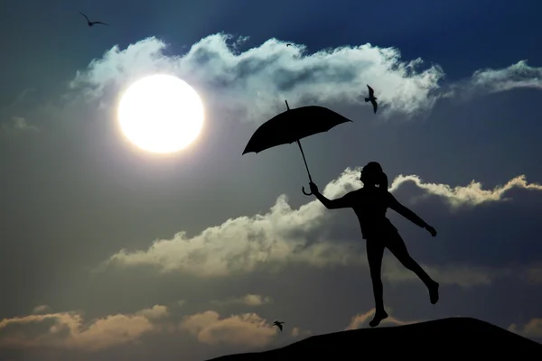 Силует парасольки жінка стрибає і захід сонця з великим сонцем, пейзаж — стокове фото