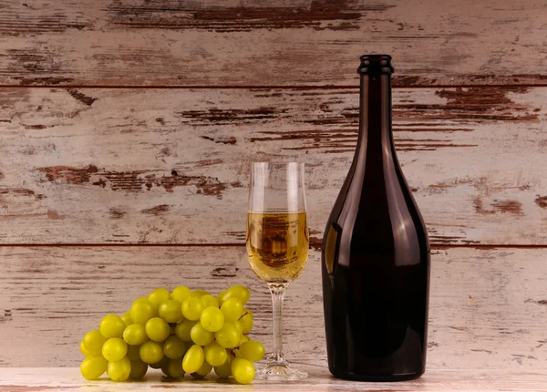 Kadeh şarap, bir şişe şarap ve üzüm gemide — Stok fotoğraf