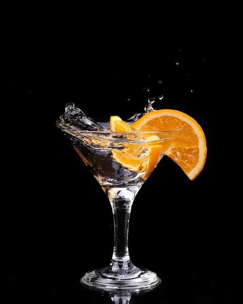 튀는 물방울 어두운 배경에 유리 위에 공기 중에 일시 중지 하는 모션에서의 스프레이와 물 한 잔에 레몬 조각. — 스톡 사진