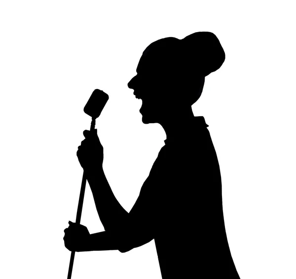 A silhouette of a woman in front of a microphone — Stock Photo, Image