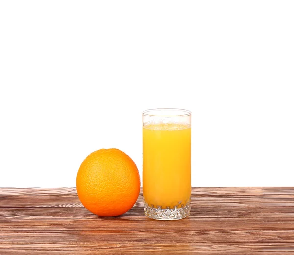 Sklenice čerstvě lisované pomerančové šťávy s plátky pomerančové poloviny na dřevěném stole — Stock fotografie