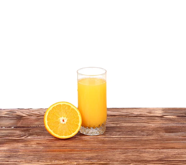 Verre de jus d'orange fraîchement pressé avec moitié d'orange tranchée sur une table en bois — Photo