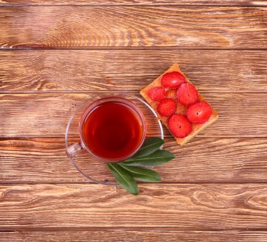 ahşap masa üzerinde çay ile tatlı pasta