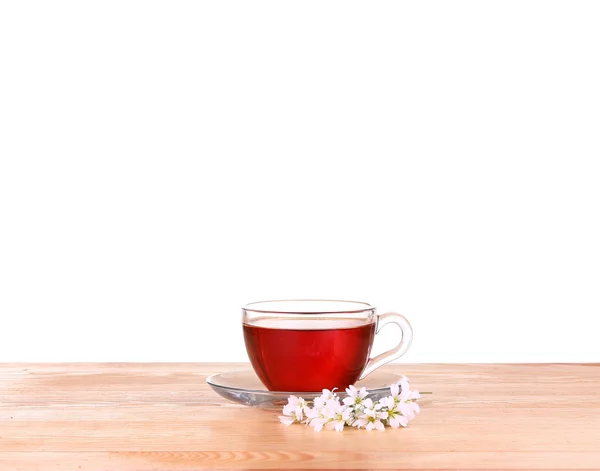 Chá de ervas em uma xícara de vidro, flores frescas em um fundo de placas de madeira — Fotografia de Stock