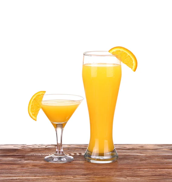 Vaso de zumo de naranja recién prensado con mitad de naranja en rodajas sobre mesa de madera — Foto de Stock