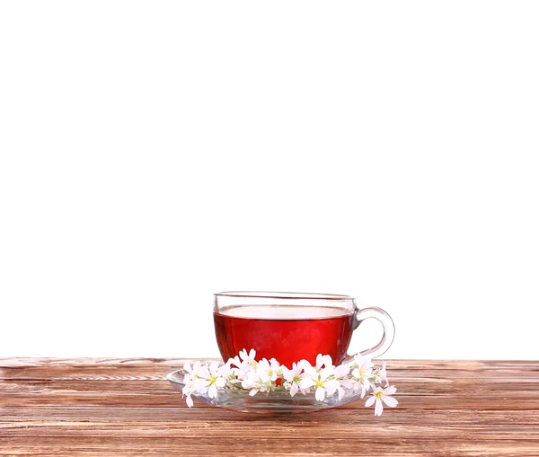 Τσάι βοτάνων σε ένα φλιτζάνι γυαλί, φρέσκα λουλούδια σε ένα φόντο από ξύλινες σανίδες — Φωτογραφία Αρχείου