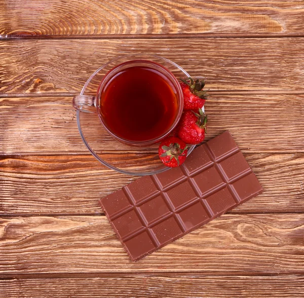 En kopp te eller kaffe. Mörk choklad. Trä bakgrund. — Stockfoto