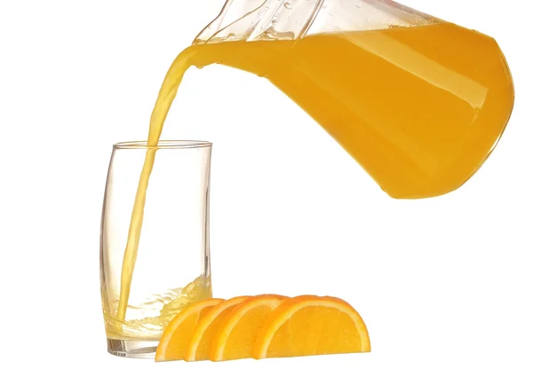 Orangensaft und Orangenscheiben isoliert auf weiß gießen — Stockfoto