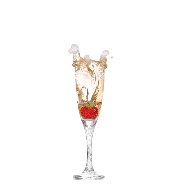 Eine einzige Erdbeere spritzt in ein Glas Champagner — Stockfoto