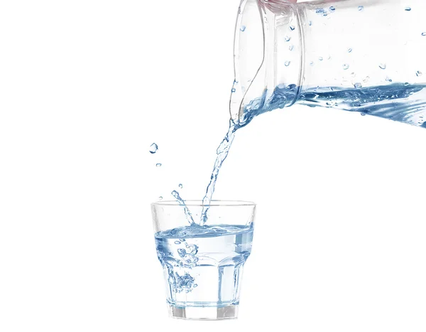 Verser l'eau du pichet en verre sur fond blanc — Photo