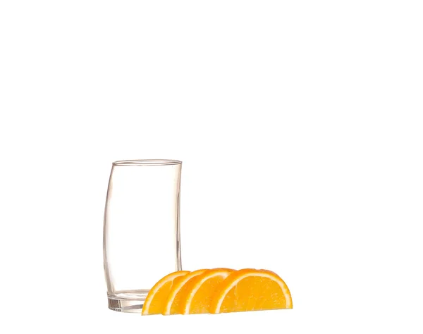 Leeg glas en segmenten van Oranje op een witte isoleren — Stockfoto