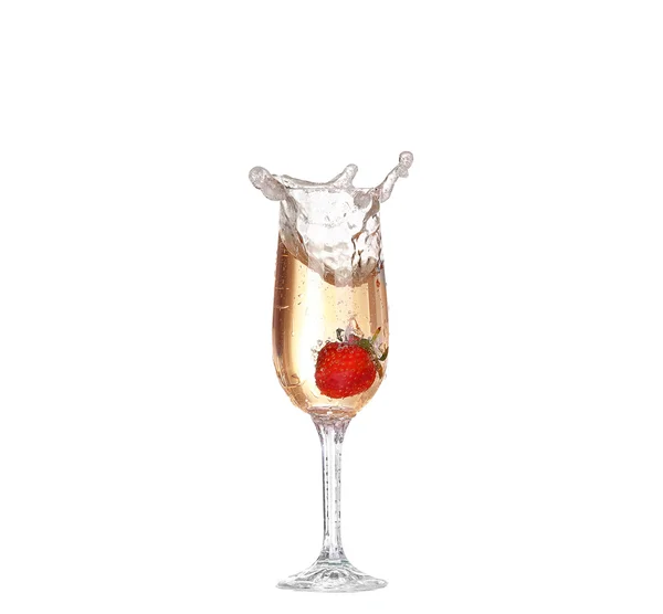 Eine einzige Erdbeere spritzt in ein Glas Champagner — Stockfoto