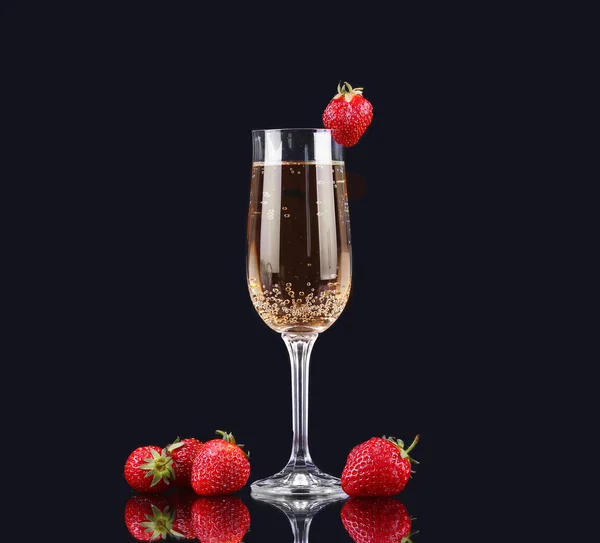 Glas kalten Champagners mit Erdbeeren auf schwarzem Hintergrund — Stockfoto