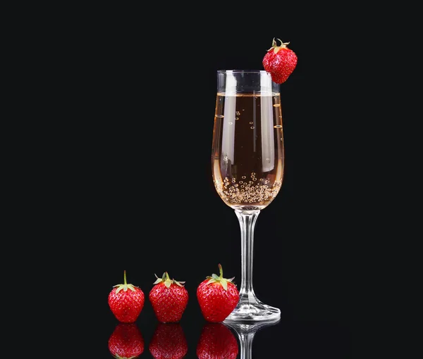 Glas kalten Champagners mit Erdbeeren auf schwarzem Hintergrund — Stockfoto