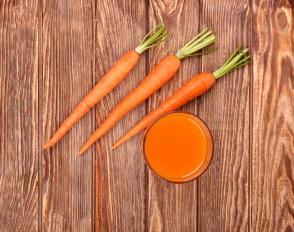 Freshly washed whole carrots on old wooden table.top view — Stock Photo, Image