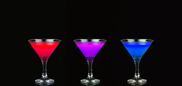 Cosmopolitan cocktail in nice red, purple and blue in front of a black background — Stock Photo, Image