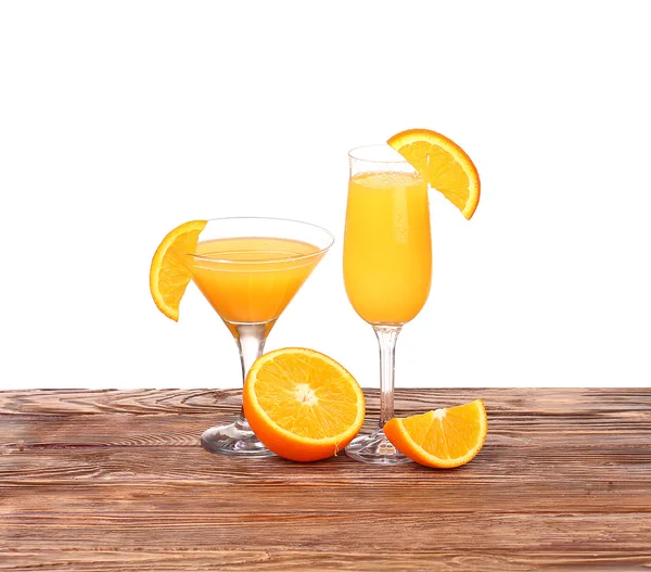 Verre de jus d'orange fraîchement pressé avec moitié d'orange tranchée sur une table en bois — Photo