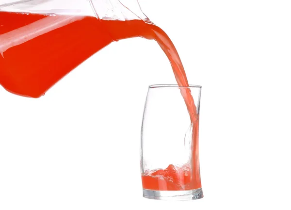 Verter zumo de pomelo en un vaso sobre fondo blanco — Foto de Stock