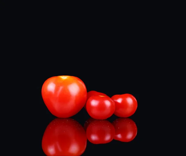 Färska tomater på svart bakgrund — Stockfoto