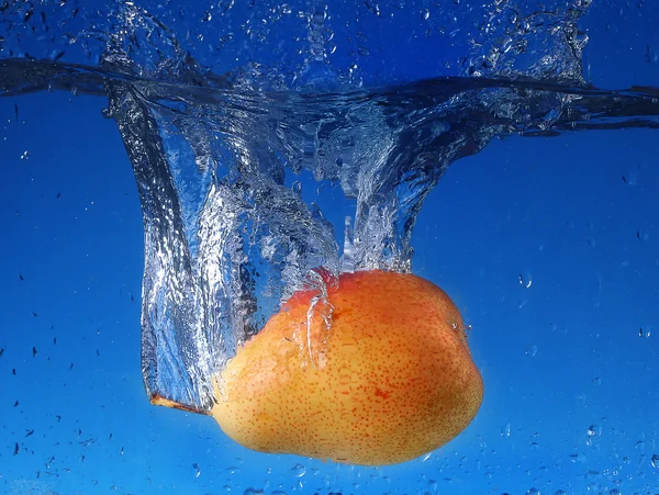 Splash with pear on a blue background — Stock Photo, Image