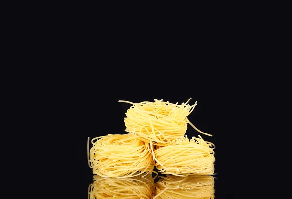 Pasta nido seca cruda con reflexión sobre el negro — Foto de Stock