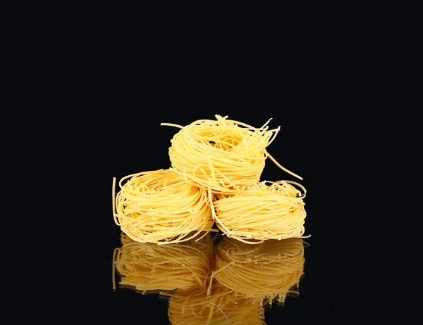 Pasta cruda a nido secco con riflesso sul nero — Foto Stock