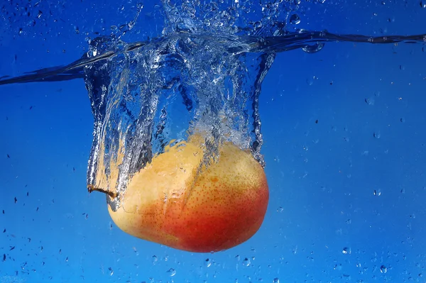 Éclaboussure de poire sur fond bleu — Photo