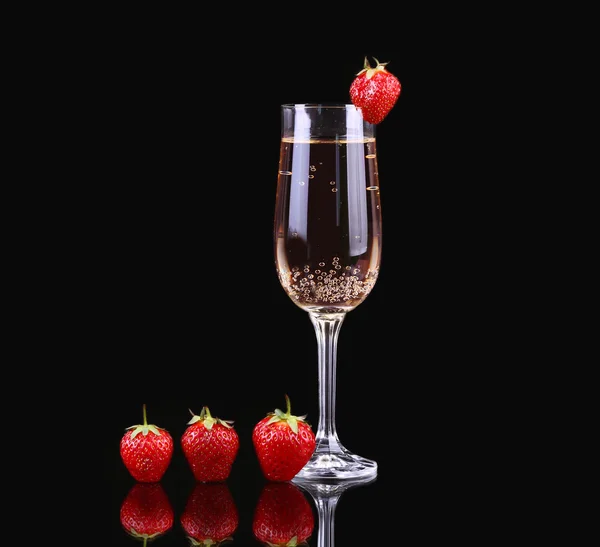 Glas kalten Champagners mit Erdbeeren auf schwarzem Hintergrund — Stockfoto