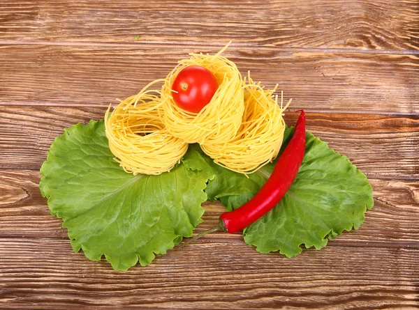 Paste pe fundal din lemn cu roșii, salată verde de piper și piper — Fotografie, imagine de stoc