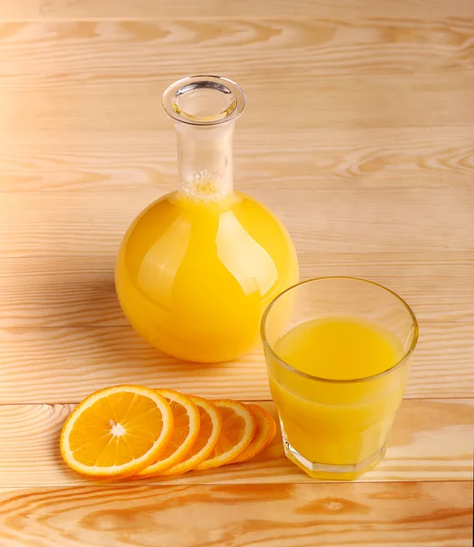 Čerstvý pomerančový džus s nakrájeným ovocem na dřevo pozadí — Stock fotografie
