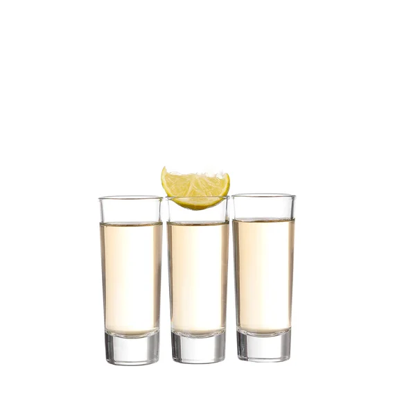 Tre colpi di tequila d'oro con calce isolata su sfondo bianco — Foto Stock