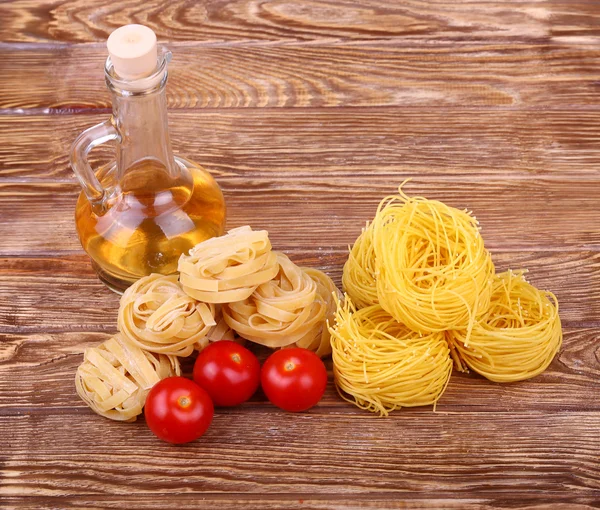 Pasta su fondo di legno con pomodoro, lattuga pepe, olio d'oliva e peperone.vista dall'alto — Foto Stock